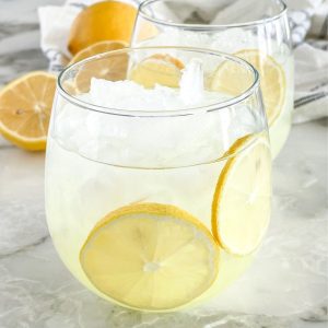 Glass of drink with sliced lemons.