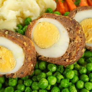 Scotch eggs with peas and carrots.